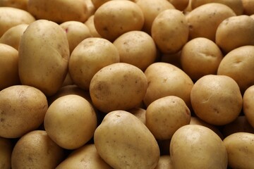 Fresh raw potatoes as background, closeup view