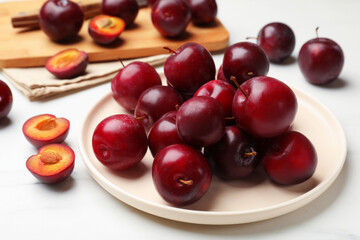 Ripe cherry plums on white table, closeup