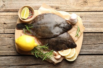 Fresh flounder fish, spices and products on wooden table, top view. Raw seafood