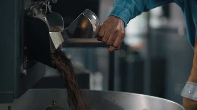 Close up male hands pushing lever in roasted coffee machine beans roasting happy smiling African American guy man worker in fabric small business carefree cafe owner barista enjoy work preparing cocoa