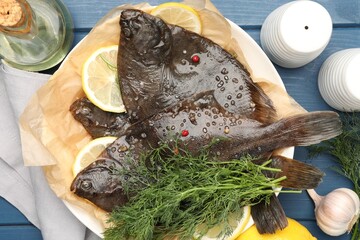 Fresh raw flounder fish and spices on blue wooden table, flat lay. Seafood
