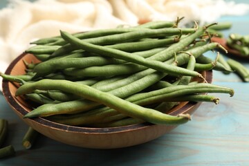 Many raw green beans on blue wooden table, closeup