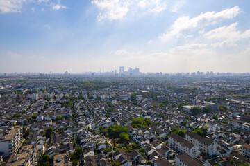 Suzhou China cityscape stretching across the horizon under a bright sky.