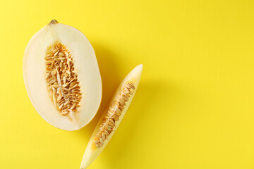 Cut fresh ripe melon on yellow background, flat lay. Space for text