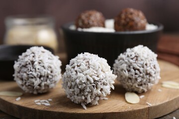 Delicious homemade candies with coconut flakes on table, closeup