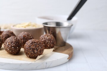 Making homemade candies. Chocolate balls and ingredients on white tiled table, closeup. Space for text