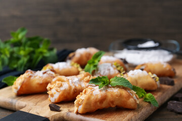 Delicious cannoli with cheese, nuts, powdered sugar and mint on table, closeup