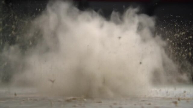Ground-level explosion with dust cloud and debris