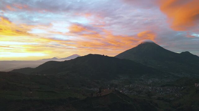 Amazing top view Sindoro mountain landscape at Dieng, Central Java with sunrise, majestic Sindoro mountain on background colorful sky on horizon at sunrise, Mount sunrise Trekking and travel concept.