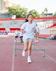 Obraz premium Young children having athletic exercise class running on the track, healthy lifestyle and children sport education concepts