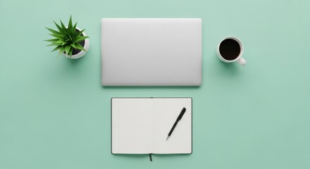 Top-down view of a closed laptop, a potted plant, a cup of coffee, and a notebook with a pen on a light green surface.