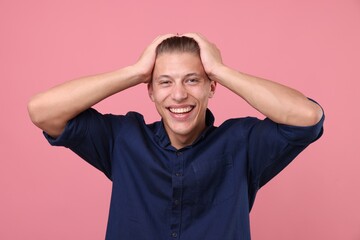 Handsome man laughing on pink background. Positive emotion
