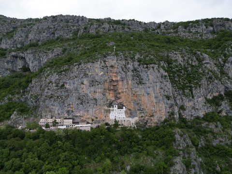 Drone shot of Ostrog Monastery in Montenegro surrounded by dramatic mountain landscape