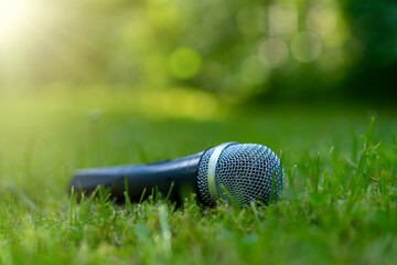 The microphone is lying on the grass.Open-air performance in the fresh air.Recording the sound of the street.