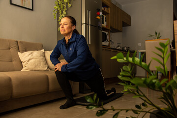 mulher adulta de 50 anos fazendo alongamento na sala de casa, estilo de vida saudável