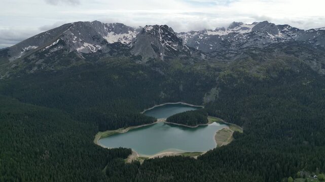 High altitude 4K drone footage of Crno Jezero Black Lake Montenegro with panoramic Durmitor mountain range aerial approach