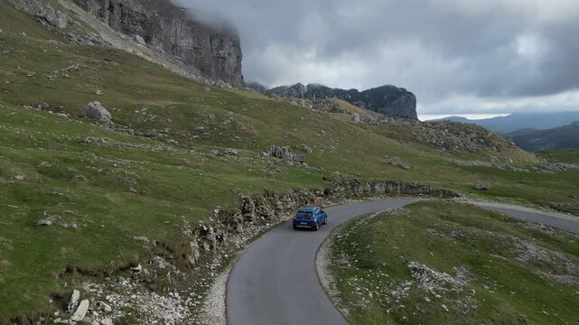 4K drone footage following car driving along scenic P14 mountain road in Durmitor Montenegro