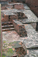 Ancient brick ruins located in Nalanda, Bihar, India. The image showcases weathered red bricks and stone structures, likely part of an archaeological site.