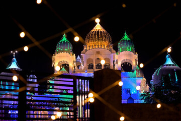 A brightly illuminated temple showcases a striking array of colorful domes and intricate architecture.