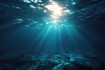 Fototapeta premium Underwater view of ocean blue abyss illuminated by sunlight beams filtering through the water surface