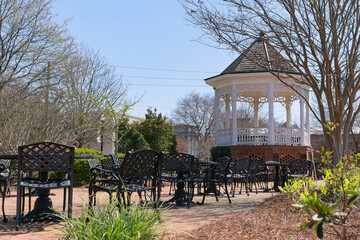 Tranquil scene of a white gazebo and outdoor seating area in Madison Town Park, Georgia, USA