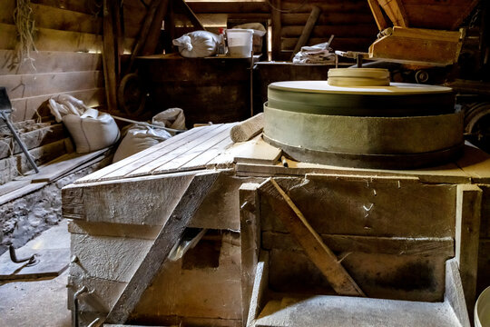 Inside the old wooden flour grinding mill. Interior of retro wooden watermill with old equipment for grinding or milling grain into flour