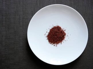 白い皿の上の赤いスパイス「スマック（sumac）」（右寄せ）