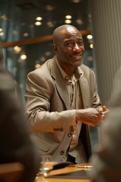 Middle age black businessman in a boardroom meeting clients