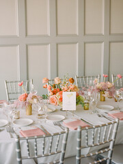 Elegant dining setup featuring flowers and silver chairs for a special event in a stylish indoor setting