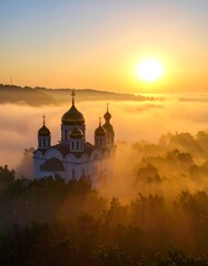 Sunrise over a church nestled in a misty landscape