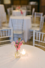 Elegant floral centerpiece on a table with candlelight in an upscale event venue during an evening gathering