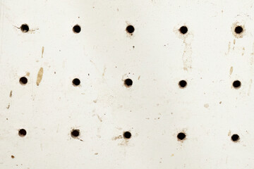 Dirty white perforated surface with grid holes
