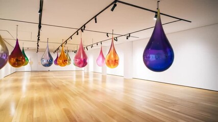 Colorful Teardrop Sculptures Hanging in Art Gallery - Powered by Adobe