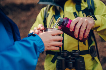 Hikers sharing water during trekking in the woods