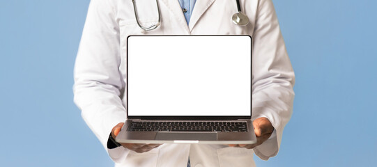 Good website for health care, doctor advice and technology for treat. African american male in white coat shows laptop with blank screen, isolated on blue background, studio shot, cropped, empty space