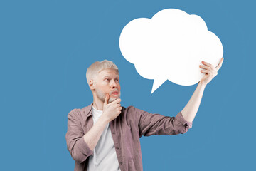 Thinking concept. Albino guy with speech bubble deep in thought posing on color background, space for text. Thoughtful man with empty word cloud, mockup for your ad or design