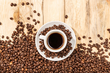 Cup of Espresso Coffee and roasted beans on wooden table background