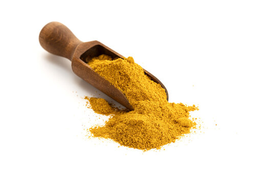 Curry powder in wooden scoop isolated on white background. Copy space