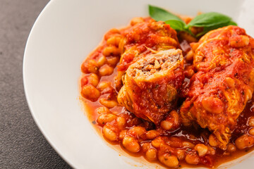 Stuffed cabbage tomato sauce with beans meat, cabbage, fresh delicious gourmet food background on the table rustic food top view copy space