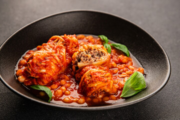 Stuffed cabbage tomato sauce with beans meat, cabbage, fresh delicious gourmet food background on the table rustic food top view copy space