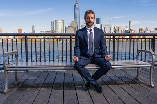 Hispanic businessman resting and meditating. Healthy yoga meditation after work. Zen businessman meditating at city skyline. Successful man meditate. Meditation of man in business suit outdoor - Powered by Adobe