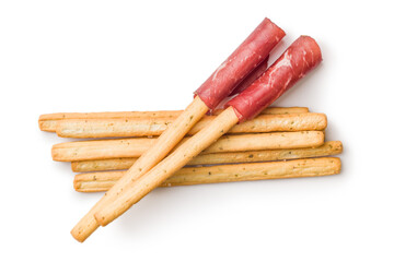 Slices of smoked bresaola and grissini sticks isolated on white background.