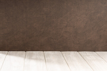 Empty white wooden table and brown textured wall background. Copy space