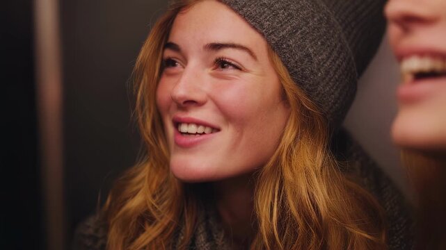 Medium shot showing two friends sharing a candid moment in an emotionsensing photo booth main subjects in clear focus rest of the booth and background beautifully out of focus.