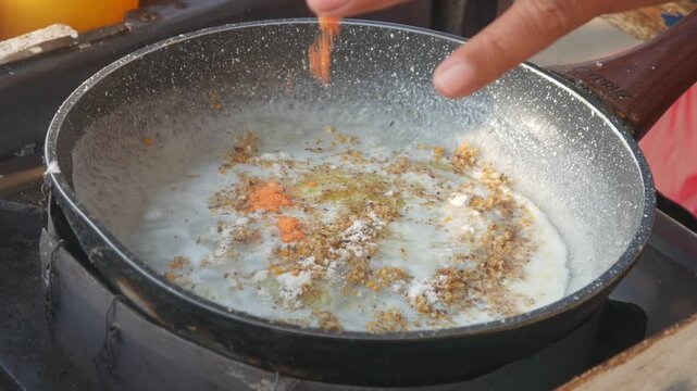 The process of cooking the Indonesian specialty papeda on a Teflon pan, sago dough is cooked until it thickens with a chewy, translucent texture. Cooking Papuan specialty