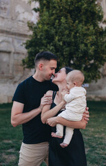 Fototapeta premium family with baby hugging in yard