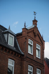 Fototapeta premium Historic townscape of Preetz, Germany, showcasing traditional red brick houses, a medieval tower, and cobblestone streets. A fine example of northern German architectural heritage