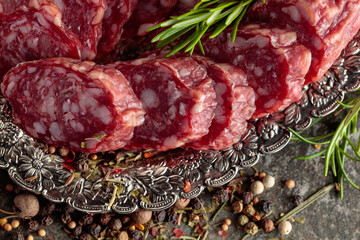 Sliced smoked sausage on a small silver tray.