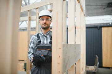 Worker carpenter assembling a modular house