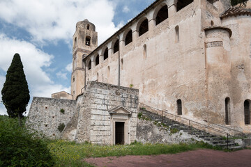 An old abandoned monastery with a bell tower and a lush green garden. The image conveys a sense of serene decay and historical significance.